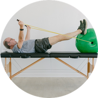 Older man using resistance bands with a green ball on a white background